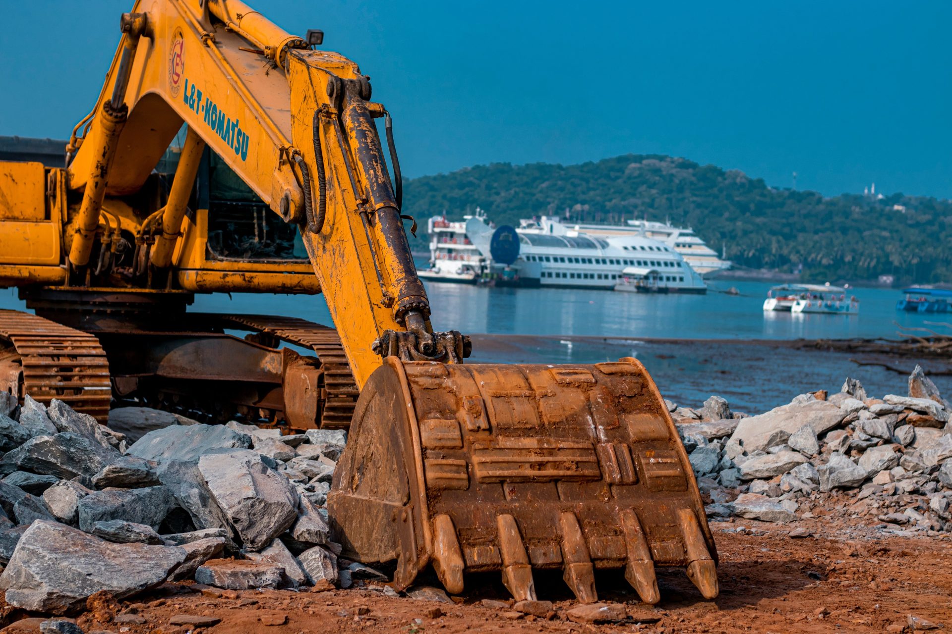 a yellow machine on a rocky shore